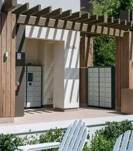 A parcel locker area with wooden pergola, white lockers, and greenery in the foreground.